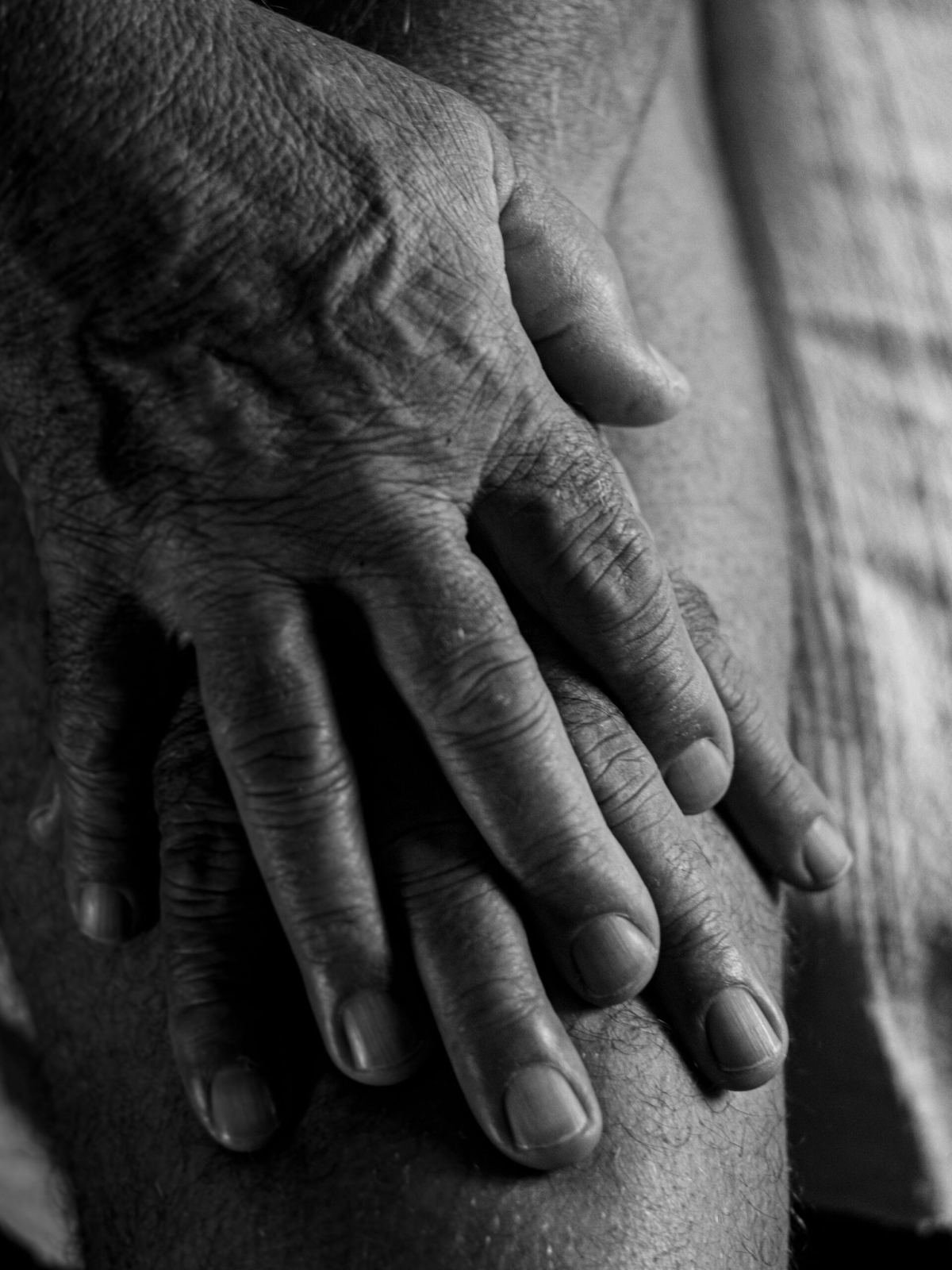 Elderly hands pressing on knee joint showing signs of arthritis - Ayurvedic arthritis treatment in Jaipur