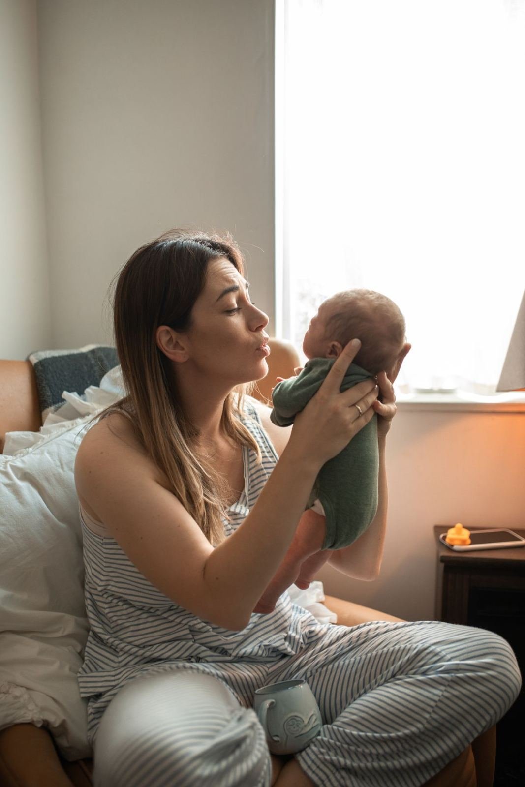 Mother gently holding newborn baby during postpartum recovery - Sutika Paricharya Ayurvedic treatment in Jaipur